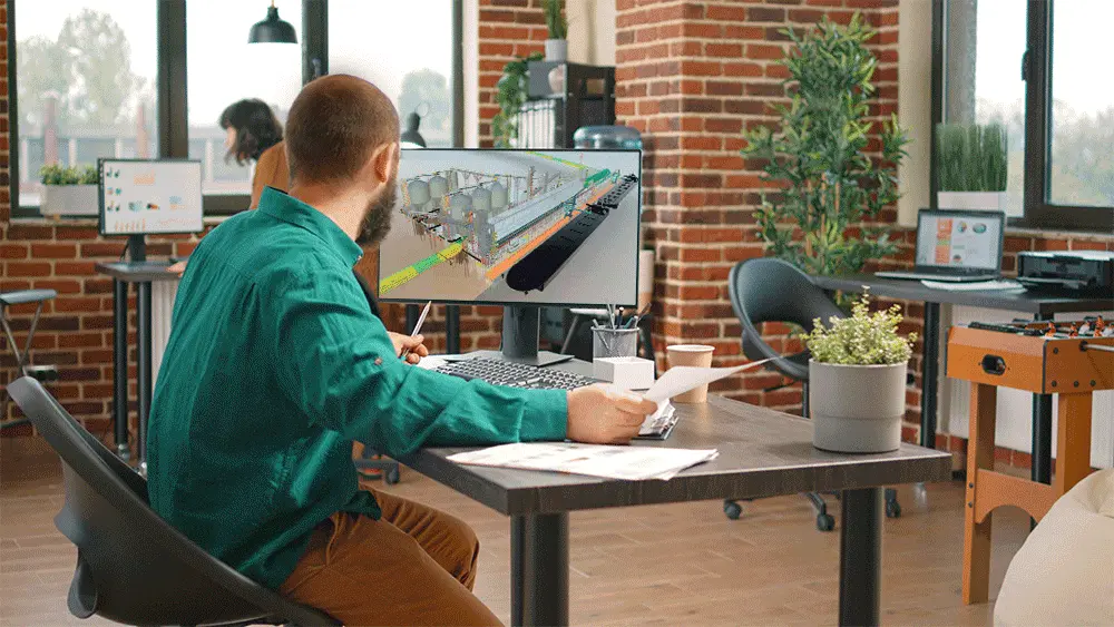 Homem branco trabalhando com modelagem e visualização 3D de um projeto BIM Homem branco visualizando modelagem 3D na tela do computador enquanto trabalha