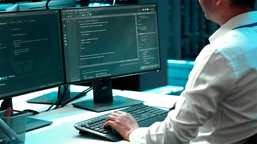 homem branco de camisa social branca usando o computador enquanto utiliza o software de modelagem BIM